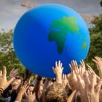 Modern illustration of diverse hands reaching for a glowing globe surrounded by icons of innovation, sustainability, and social responsibility.