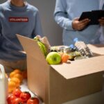 Volunteers packing food and supplies into donation boxes, representing how Seattle businesses support nonprofits and drive community impact in 2025.