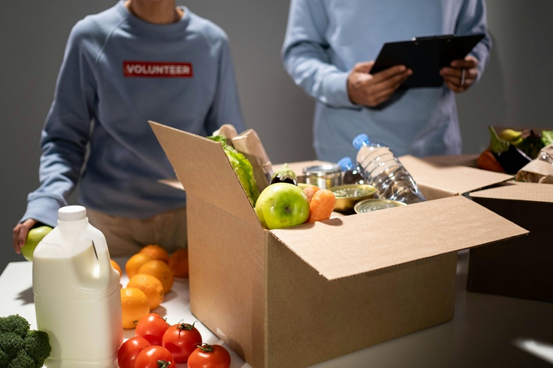 Volunteers packing food and supplies into donation boxes, representing how Seattle businesses support nonprofits and drive community impact in 2025.