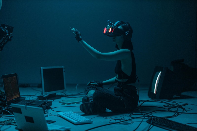Person using advanced technology in a dark workspace, representing Seattle’s innovative CSR culture and tech-driven sustainability initiatives.